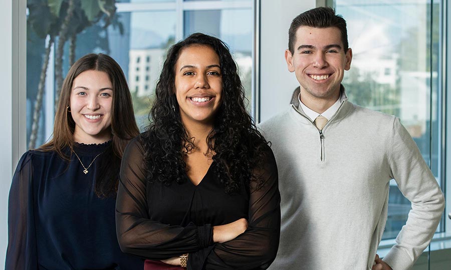 Three undergraduate business students smiling