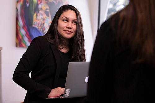 Students looking at laptop while in the field.